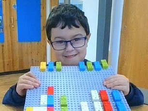 Boy with glasses and lego board